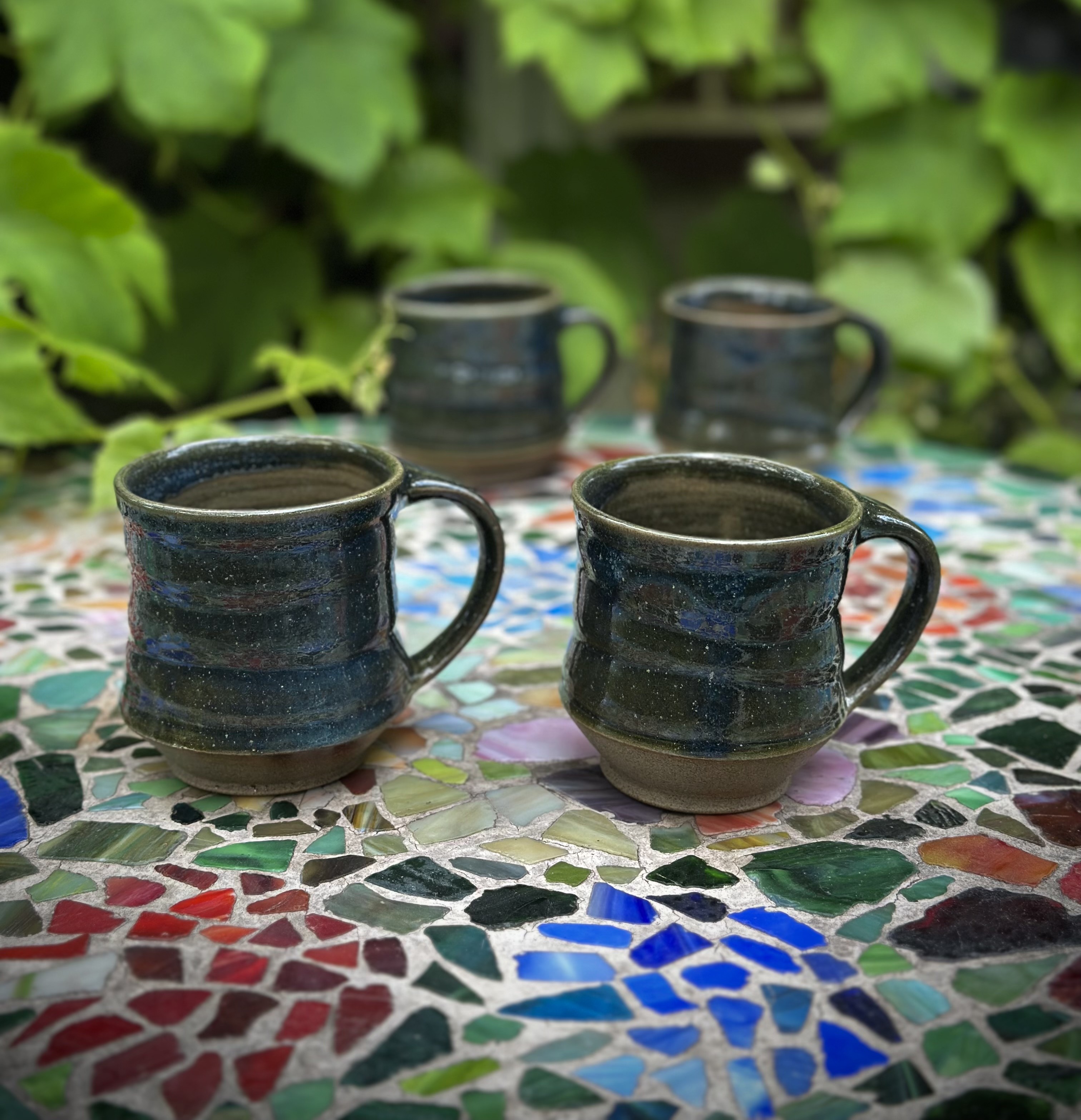 Handmade ceramic cups in a small collection.