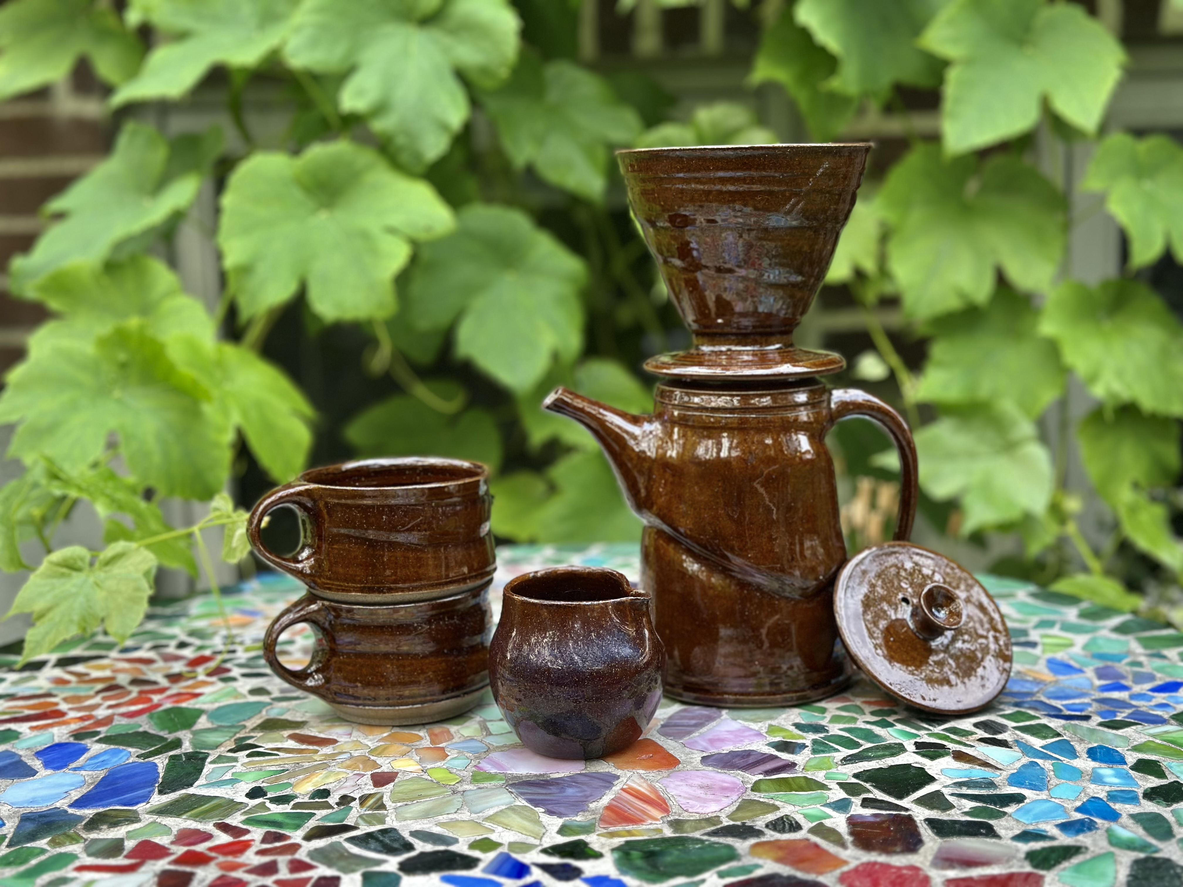 Handmade ceramic cups in earthy green, blue, cream and brown glazes.